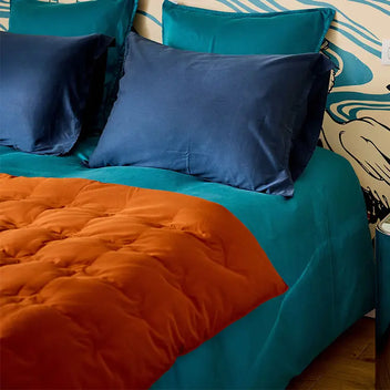 Teal blue bedding set with navy blue pillowcases and terracotta duvet